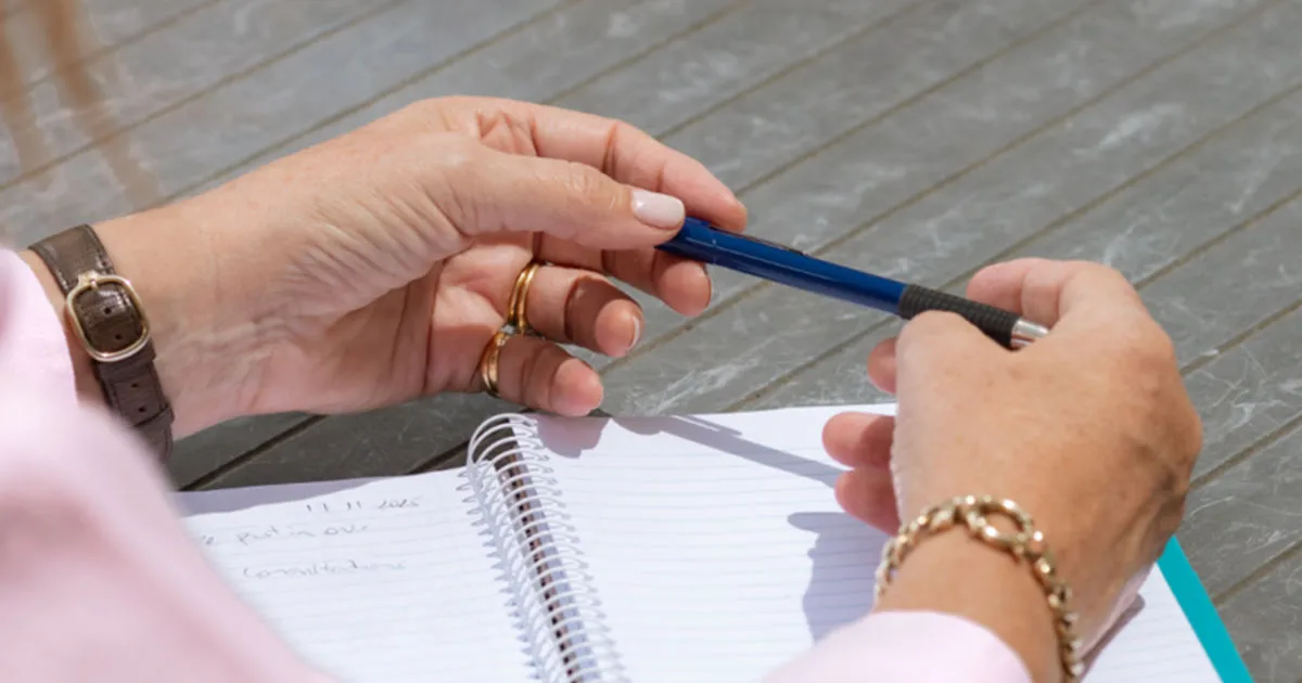 An older man and his daughter going through aged care fee paperwork at home.