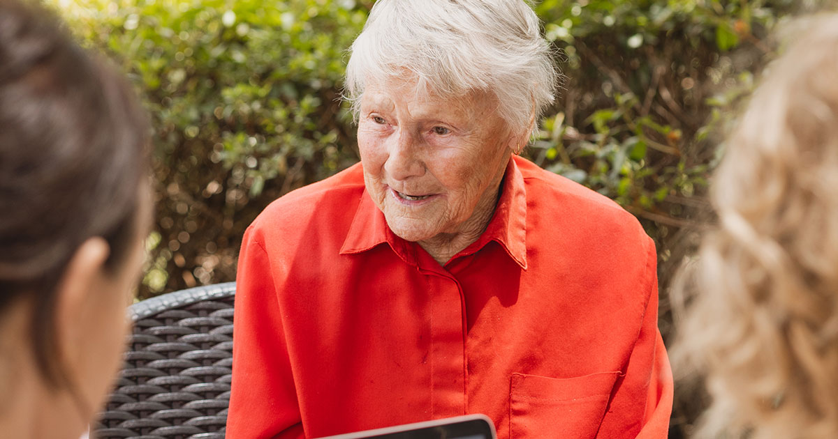 An older man and his daughter talking with an independent aged care adviser at home