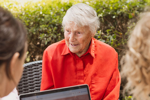 An older man and his daughter talking with an independent aged care adviser at home
