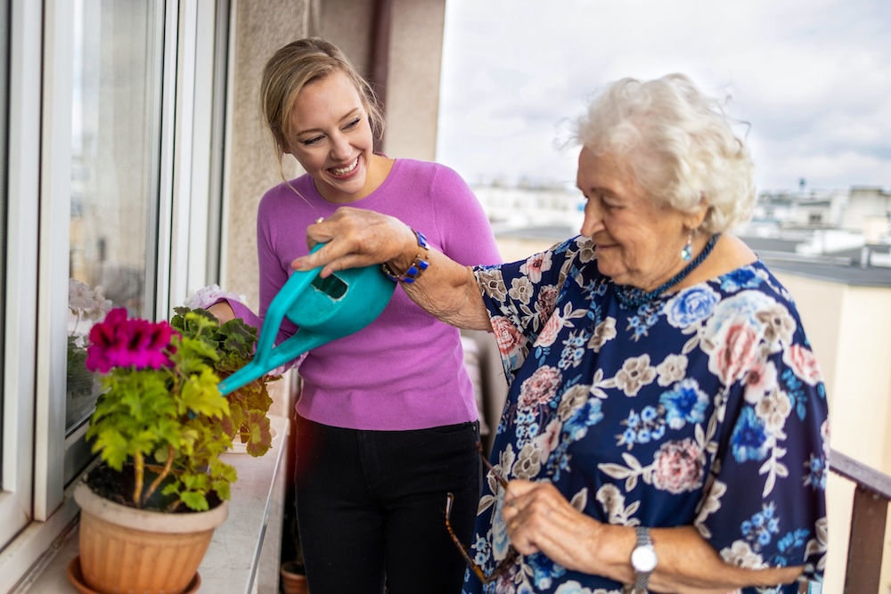 Older Lady with Care Worker on Balcony Gardening